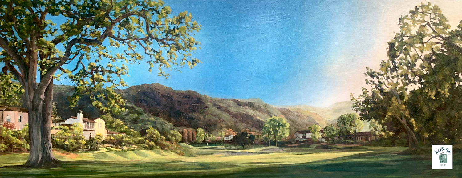 Scenic landscape with trees, grass, and mountains under a blue sky.